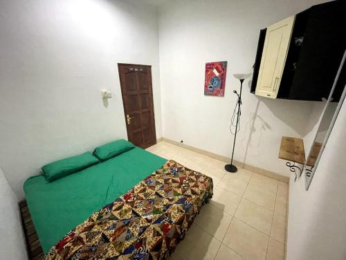 a bedroom with a bed with a green comforter at Gorga hostel in Timuran