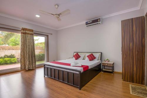 a bedroom with a bed and a large window at Serene Villa by StayVista - A Hill-View Villa with Plunge pool in Karjat