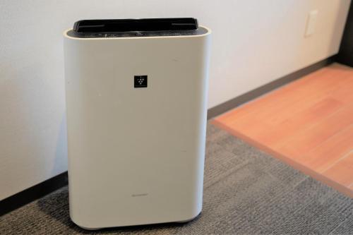a white refrigerator with a cell phone on top at Hotel Katsuyama Premiere in Matsuyama