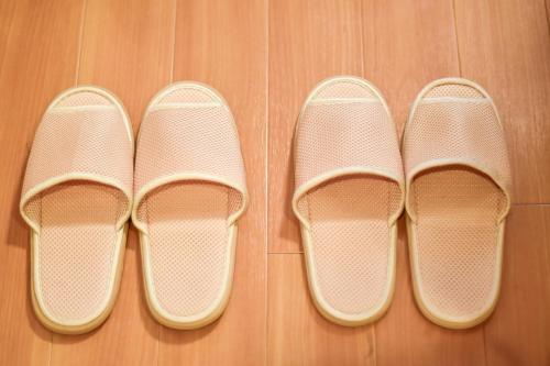 two pairs of shoes sitting on a wooden floor at Hotel Katsuyama Premiere in Matsuyama