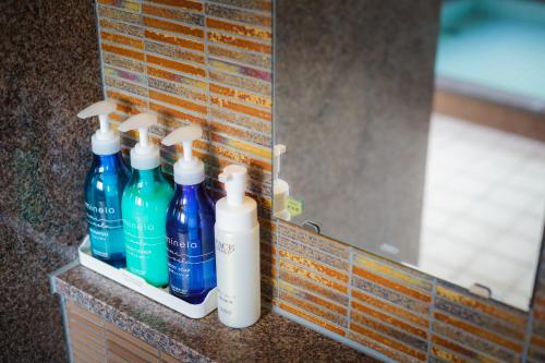 a row of bottles sitting on a counter in front of a mirror at Hotel Katsuyama Premiere in Matsuyama