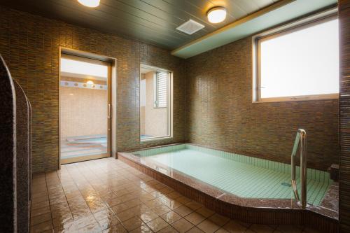 松山市にあるホテル勝山プレミアの大きなバスルーム(窓付きのバスタブ付)