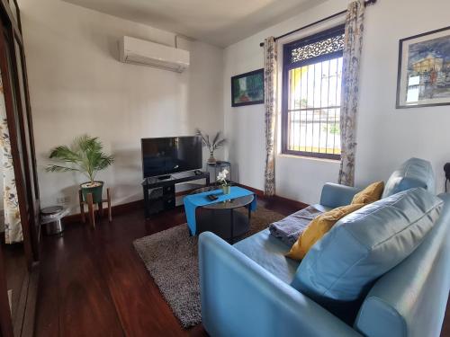 uma sala de estar com um sofá azul e uma televisão em Sittisang1920 em Kanchanaburi