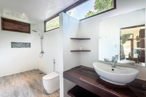 a bathroom with a sink and a toilet at Ohana Resort Siargao in General Luna
