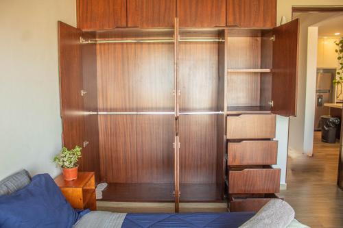 a room with a wooden book shelf and a couch at NEW Terra Condo w/ Infinity Pool in Cabo San Lucas