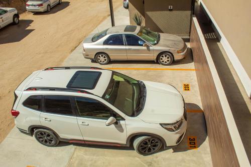 a white suv parked in a parking lot at NEW Terra Condo w/ Infinity Pool in Cabo San Lucas