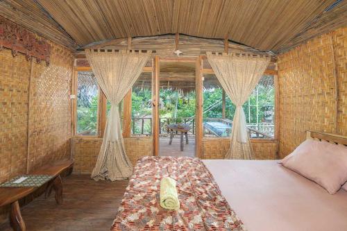 a bedroom with a bed in a room with windows at Onong's Homestay & Cafe in Tomohon