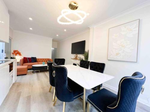 uma sala de estar com uma mesa branca e cadeiras em Churchill’s Rest em Sydney