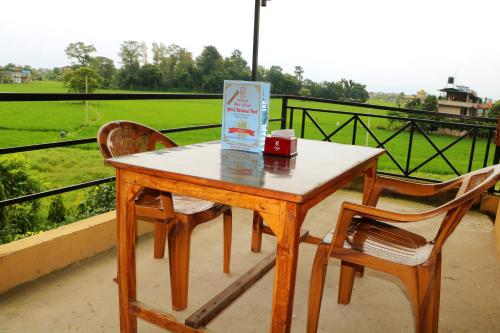 a wooden table with two chairs and a box on a balcony at Hotel National Park Sauraha- Homely Stay and Peaceful Location with Jungle Safari arrangements in Sauraha