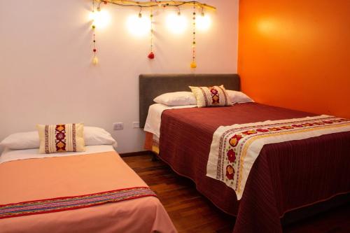 a room with two beds and lights on the wall at Apartamento Altoandino in Ayacucho