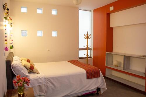 Apartamento Altoandino في اياكوتشو: غرفة نوم بسرير ونافذة