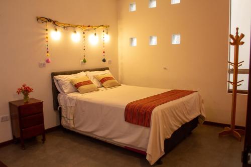 a bedroom with a bed with lights on the wall at Apartamento Altoandino in Ayacucho