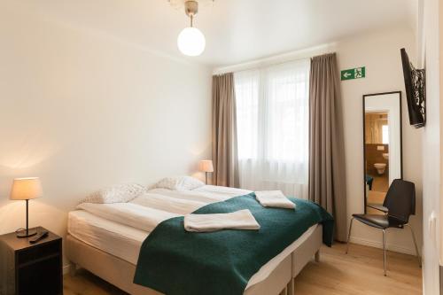 a bedroom with a bed with two towels on it at Guesthouse Galtafell in Reykjavík