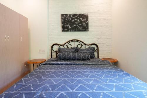 1 dormitorio con 1 cama azul y 2 sillas en G House Hoian en Hoi An
