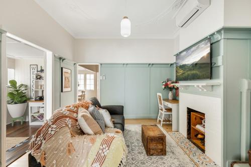 a living room with a couch and a fireplace at Cherry Tree Cottage! CBD Magic! in Toowoomba