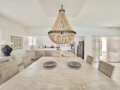 a large dining room table with chairs and a chandelier at Villa White Horizon by Sealodge in Pointe aux Canonniers