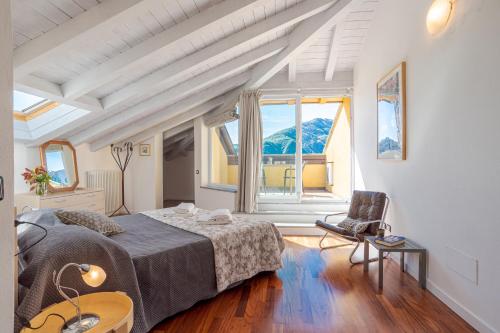 een slaapkamer met een bed, een stoel en een raam bij Villa Tremezzo in Tremezzo