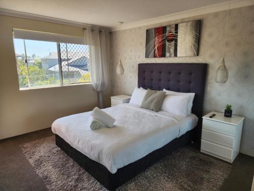 sypialnia z dużym łóżkiem i dużym oknem w obiekcie Bayview Bay Apartments and Marina w mieście Gold Coast