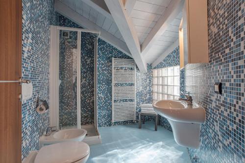 een blauwe betegelde badkamer met 2 wastafels en een douche bij Villa Tremezzo in Tremezzo
