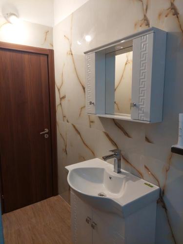 La salle de bains est pourvue d'un lavabo et d'un miroir. dans l'établissement Didi House, à Sandanski