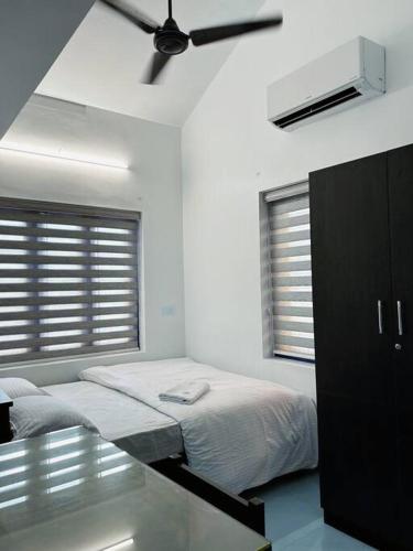 a bedroom with a bed and a ceiling fan at Saaketh Holiday Home(2) in Kozhikode