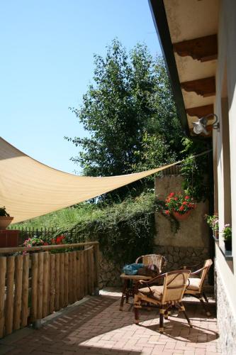 a patio with a hammock and a table and chairs at Casa Pendola in Agerola