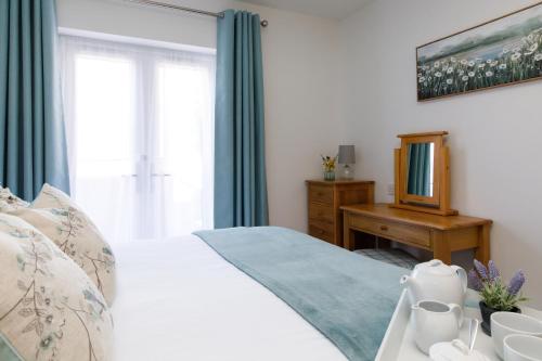 a bedroom with a white bed and a window at The Stables in Chichester