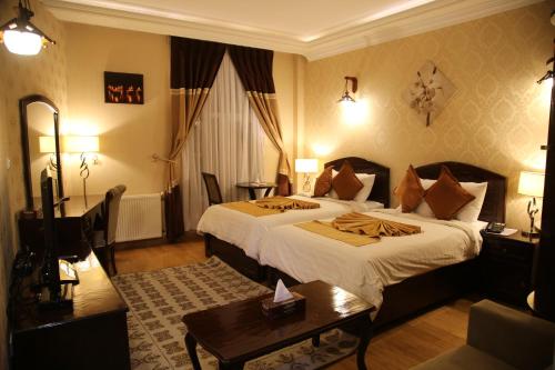 Cette chambre comprend un grand lit et une table. dans l'établissement Gholghola Hotel by the Buddhas of Bamyan, 