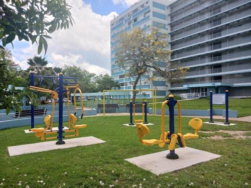 einen Park mit Spielplatz im Gras in der Unterkunft Elegancia Acogedora: Tu Rincón en San Juan in San Juan