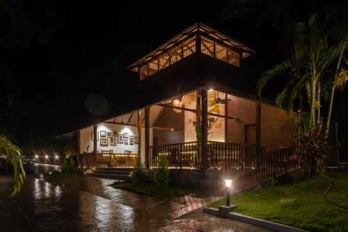 Una casa bajo la lluvia por la noche en Shanthi Kunnj Riverside Exotica Chikmagalur, en Chikmagalur