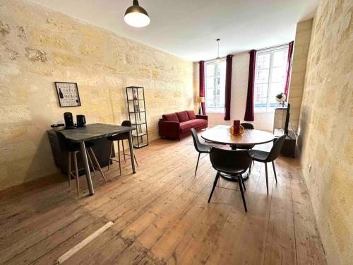 - un salon avec deux tables et un canapé dans l'établissement 2 - Hypercentre - FREE Parking - clim - wifi - netflix, à Libourne