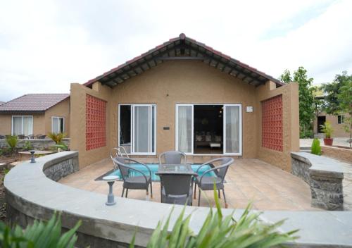 a patio with chairs and a table in front of a house at Waterstone resort in Linga