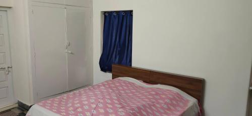 a bedroom with a bed and a blue curtain at The Ghosh's Home stay in Hyderabad