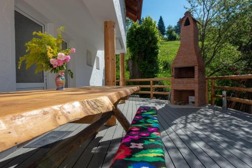 a wooden deck with a wooden table and a rug at Casa Pădurarului in Holbav