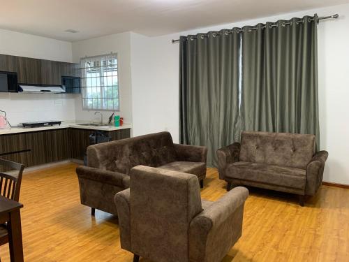 uma sala de estar com duas cadeiras e um sofá em Ortega Villa em Kuching