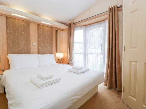 een slaapkamer met een groot wit bed en een raam bij Owl in Leominster