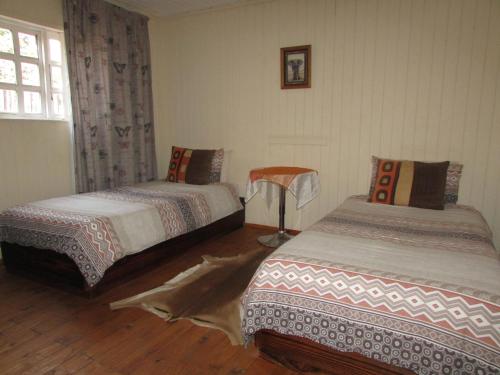 um quarto com 2 camas e uma janela em Lush Bush at Loodswaai Cullinan close to Dinokeng em Rust de Winter