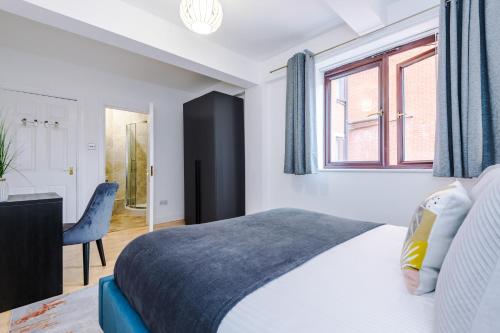sypialnia z łóżkiem, biurkiem i oknem w obiekcie Manchester City Centre 2 bed apartment w Manchesterze