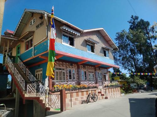 a colorful house with flags on the side of it at Vamoose Latpanchor Homestay in Mangpu