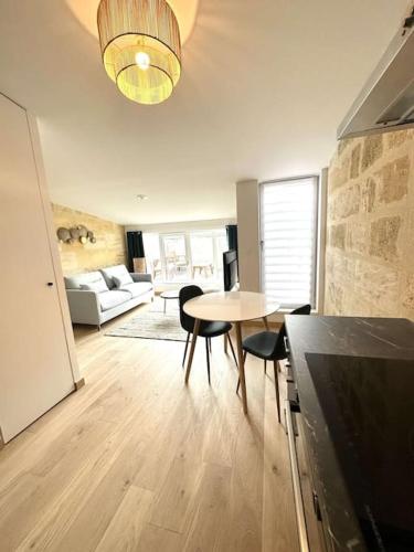 un salon avec une table, des chaises et un canapé dans l'établissement 5- Hypercentre - 4pers - clim - terrasse - Netflix, à Libourne