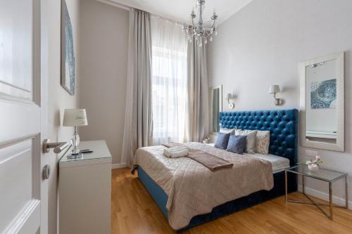 een slaapkamer met een blauw bed en een kroonluchter bij Luxury Royal Residence in the Heart of Budapest in Boedapest