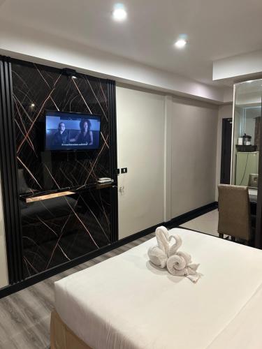 a room with a tv and a bed in a room at Maleez Lodge in Pattaya Central