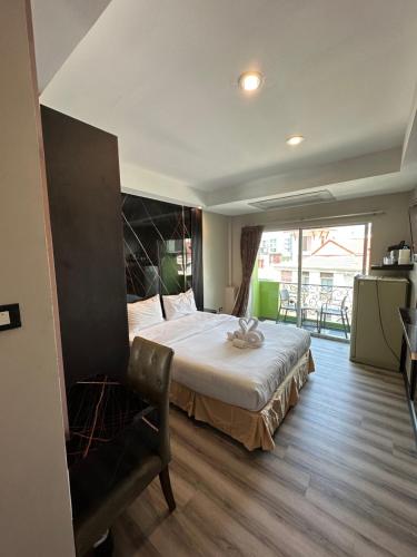 a bedroom with a large bed and a large window at Maleez Lodge in Pattaya