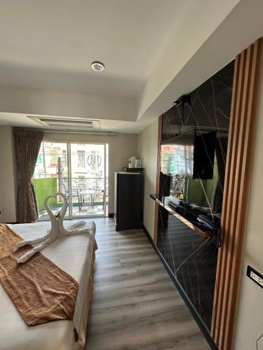 a hotel room with a bed and a television at Maleez Lodge in Pattaya
