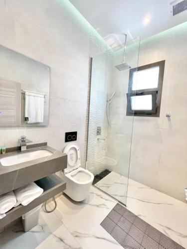 a bathroom with a toilet and a sink and a shower at Rosella Chalet 2 in Jabal Al Akhdar