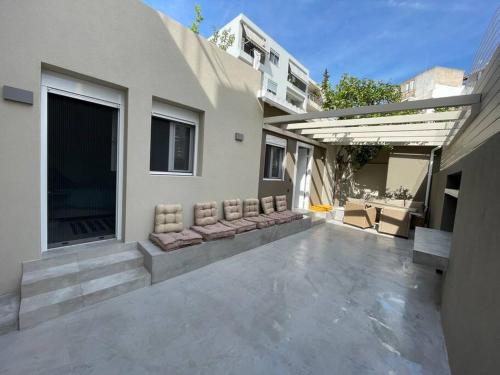 a patio of a house with cushioned chairs at House center of Athens, near Acropolis in Athens