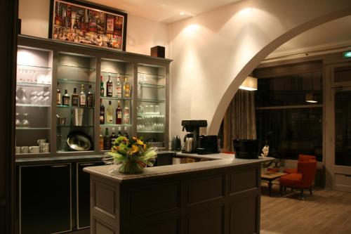 a bar with a sink and a counter with bottles at La Maison Normande in Trouville-sur-Mer