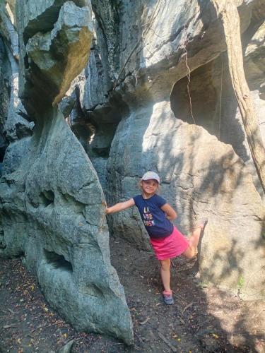 a young girl standing on a rock formation at RAMMANG-RAMMANG HOUSE in Maros