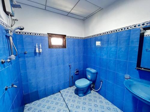 a blue bathroom with a blue toilet and a sink at Urban Galle Villa in Galle