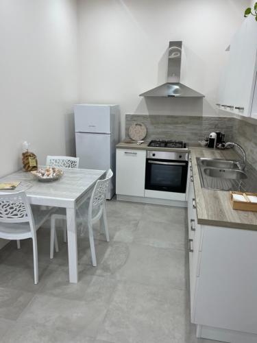 a kitchen with a table and a stove and a sink at Case vacanze LULU in Seclì